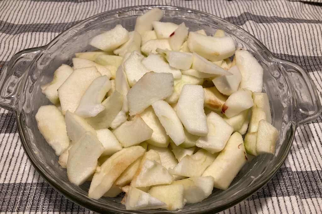 Sliced macoun apples in pyrex pie plate for apple crisp
