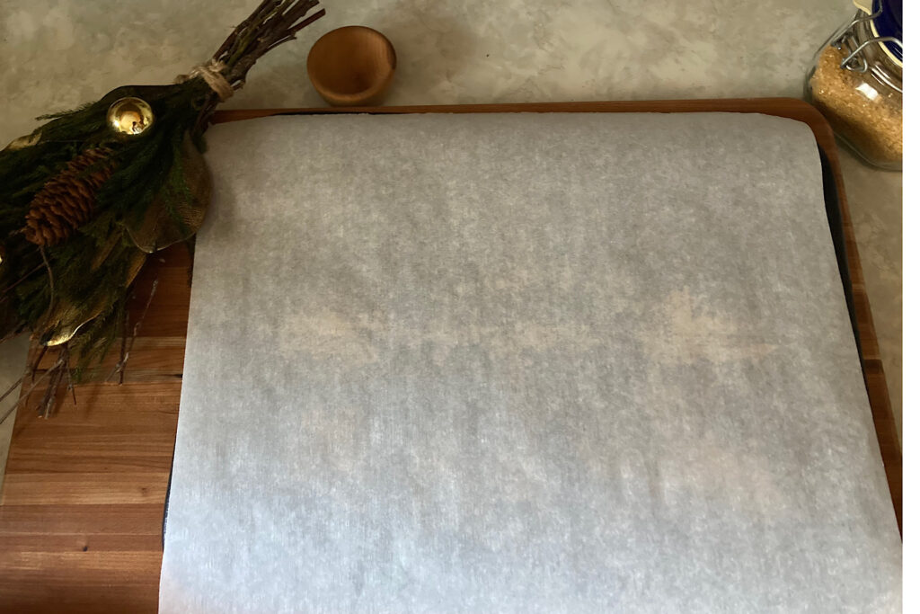 Pizza stone on cutting board with parchment