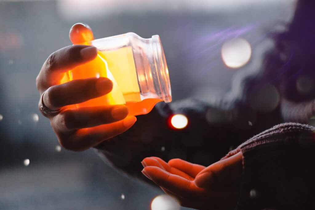 Honey jar pouring into open palm