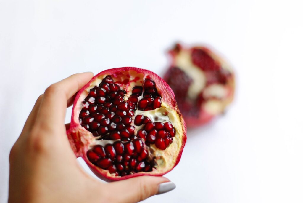 Hand holding sliced pomegranate