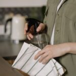 Woman Spraying Countertop with Cleanser and Towel