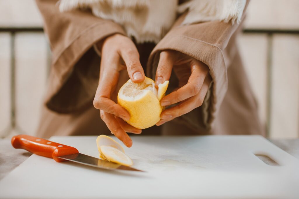 Woman's hands peeling fresh lemon for Grain Alcohol Spray Sanitizer