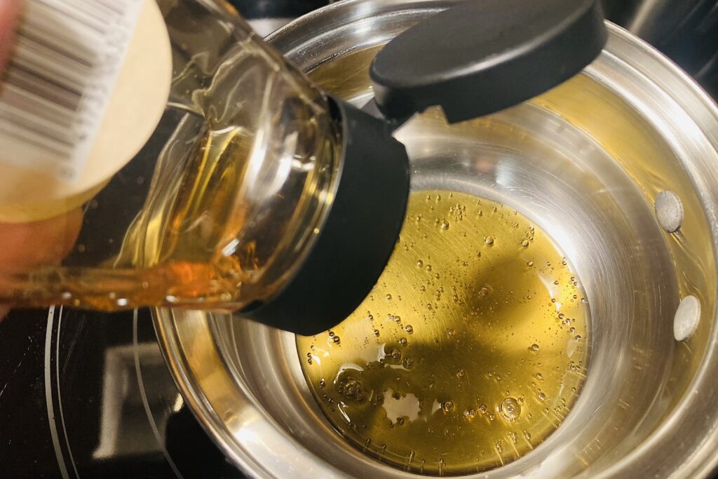 Honey Bottle Squeezing into Saucepan