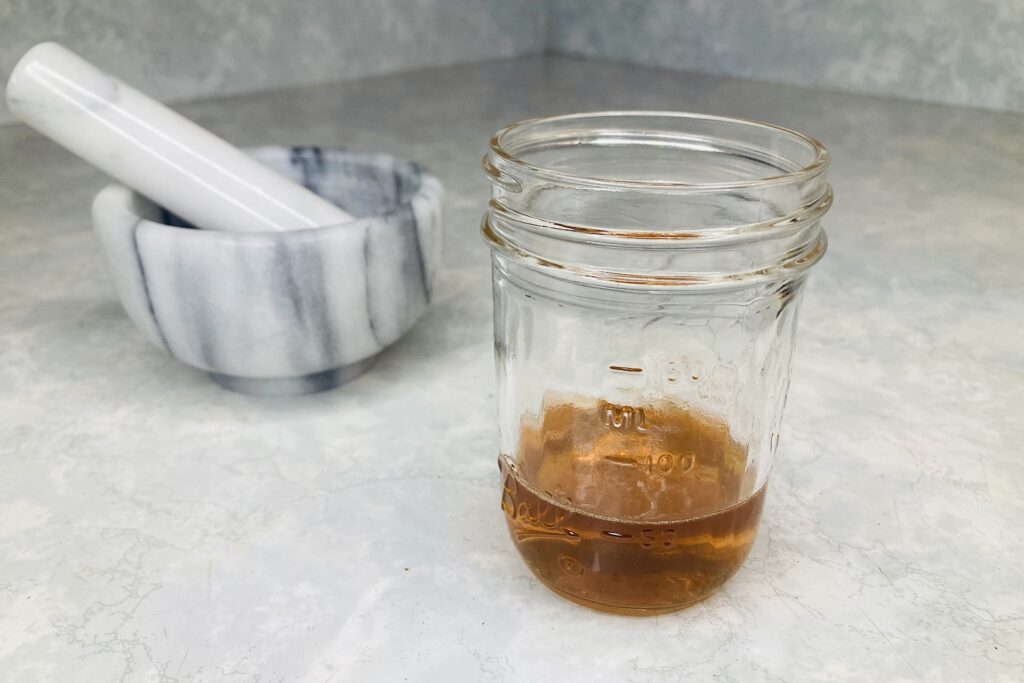 Mortar and Pestle with Mason Jar of Honey-Basil Syrup