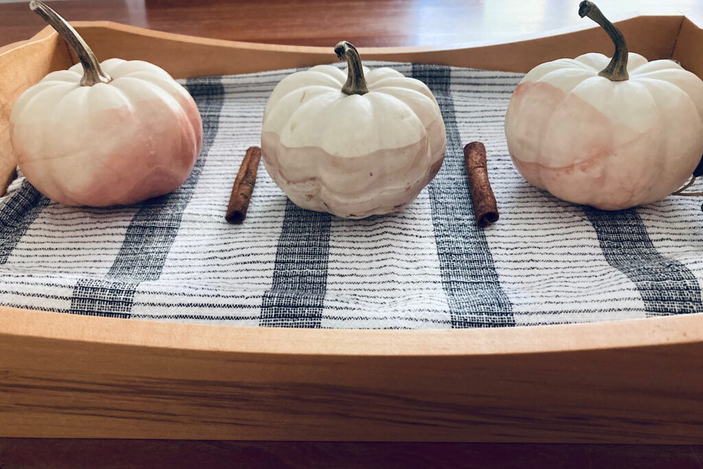 White enamel-dipped pumpkins in serving tray.