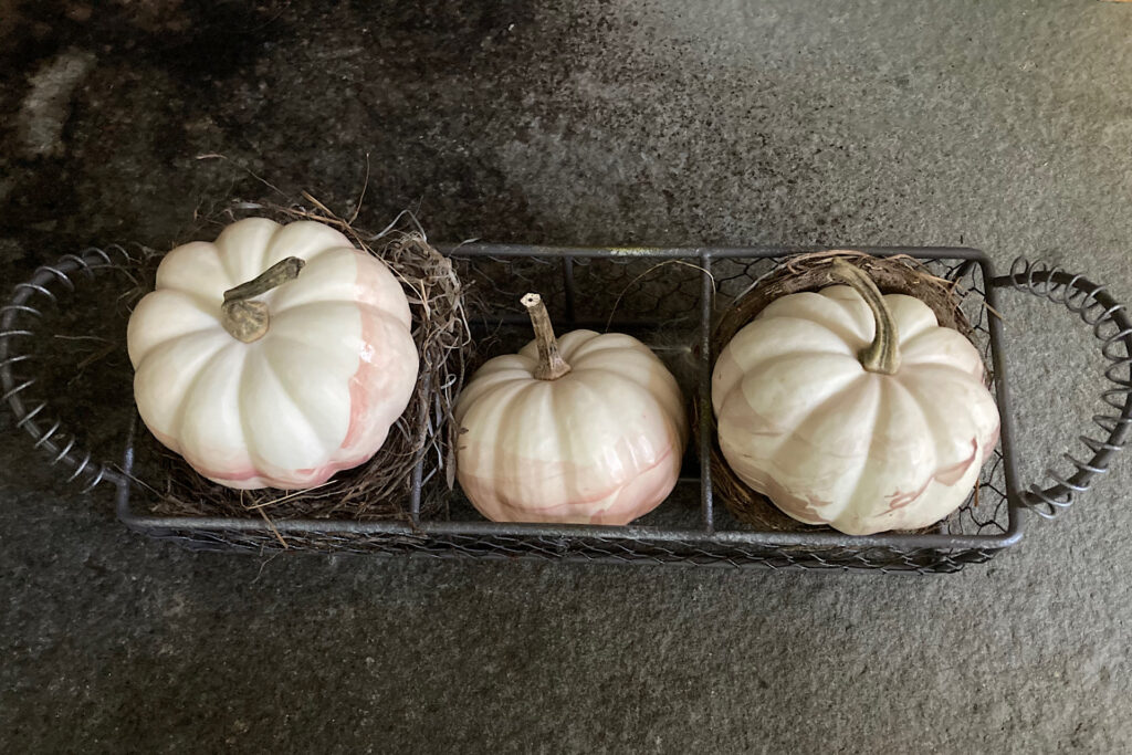 Enamel-Dipped Pumpkins in wire basket on slate.