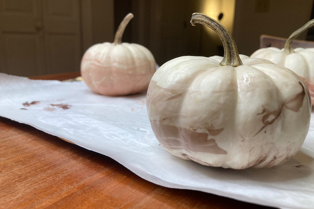 Nail enamel-dipped pumpkins on parchment.