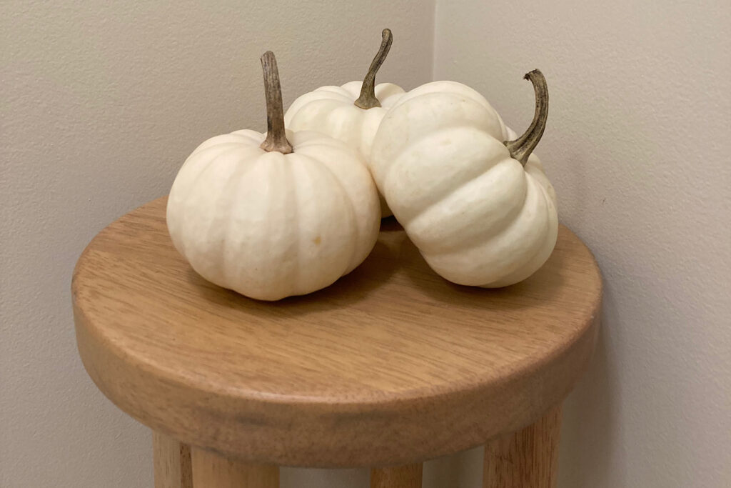 Clean white pumpkins on a stool.