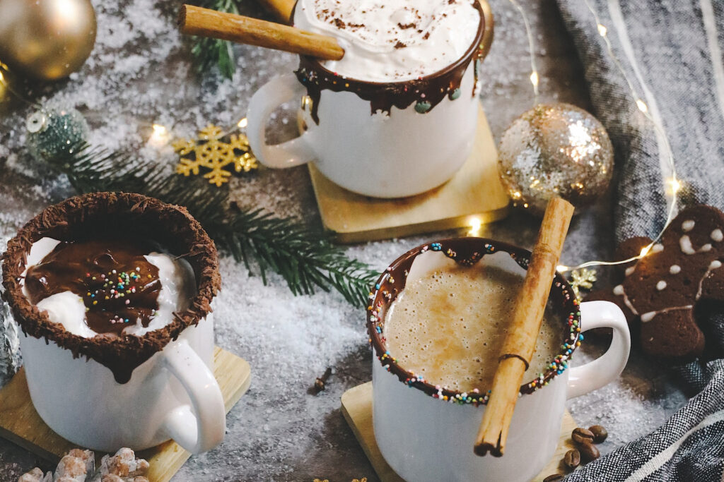 Hot cocoa mugs with chocolate rims and cinnamon stick stirrers