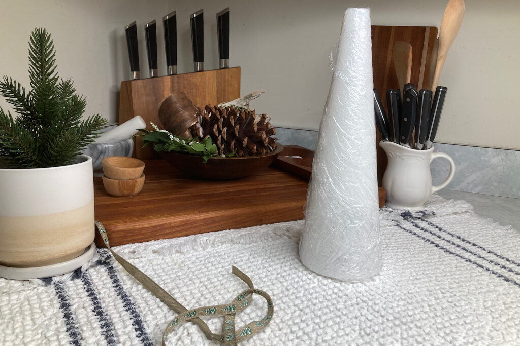 Styrofoam Christmas Tree Cone Wrapped in Plastic Wrap on Kitchen Counter