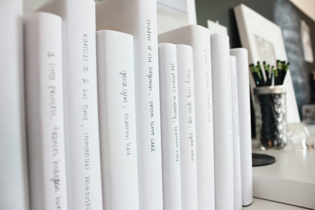 Books bound in white paper with handwriting on spine