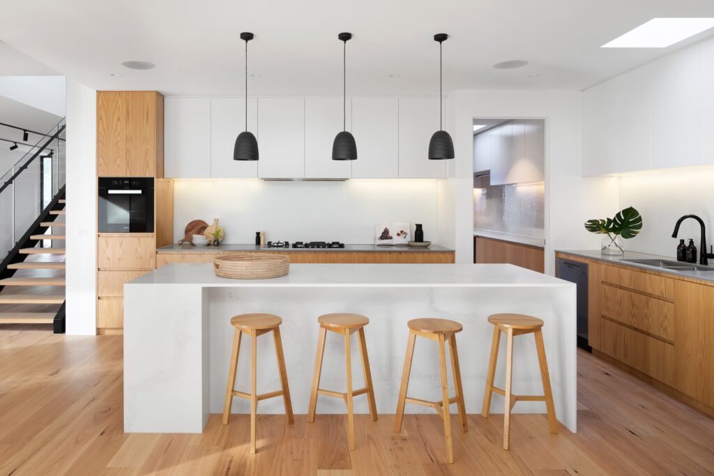 Minimal white kitchen with wood and black accents