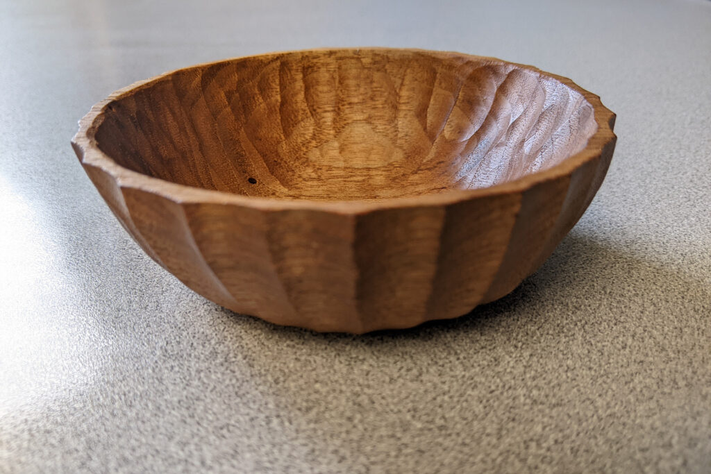 Hand carved walnut bowl on grey countertop