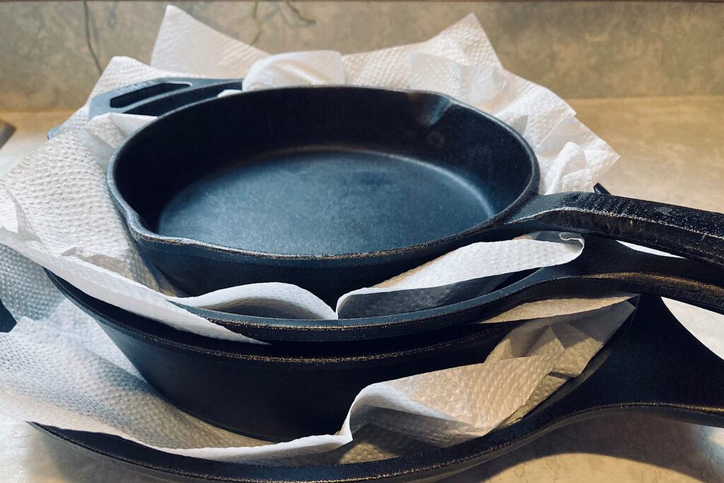 Cast iron pans with paper towels stacked between