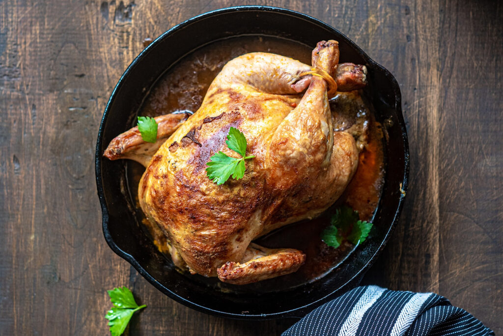 Golden brown baked chicken in cast iron pan