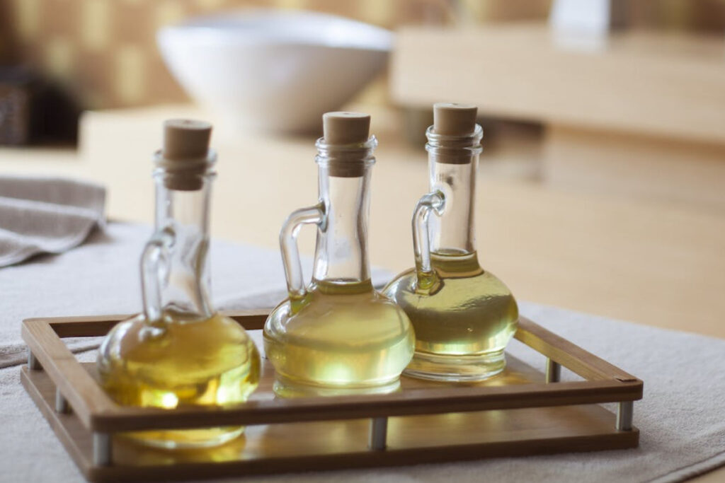 Three cooking oil cruets in tray on countertop