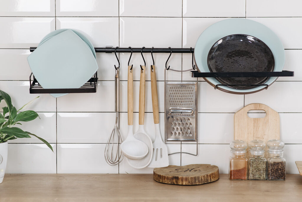 silicone spatulas and kitchen items hanging on tile backsplash