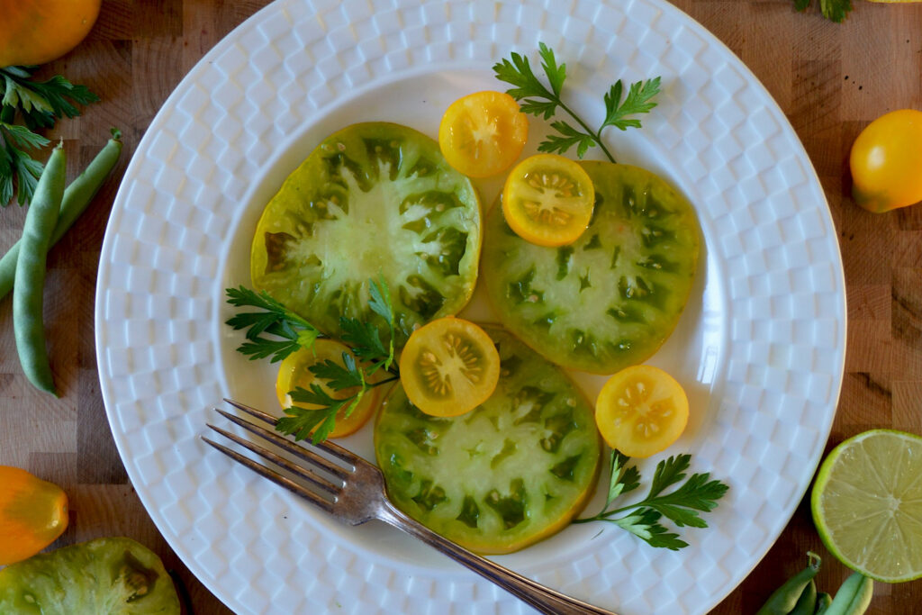 Sliced yellow tomatoes on white plate