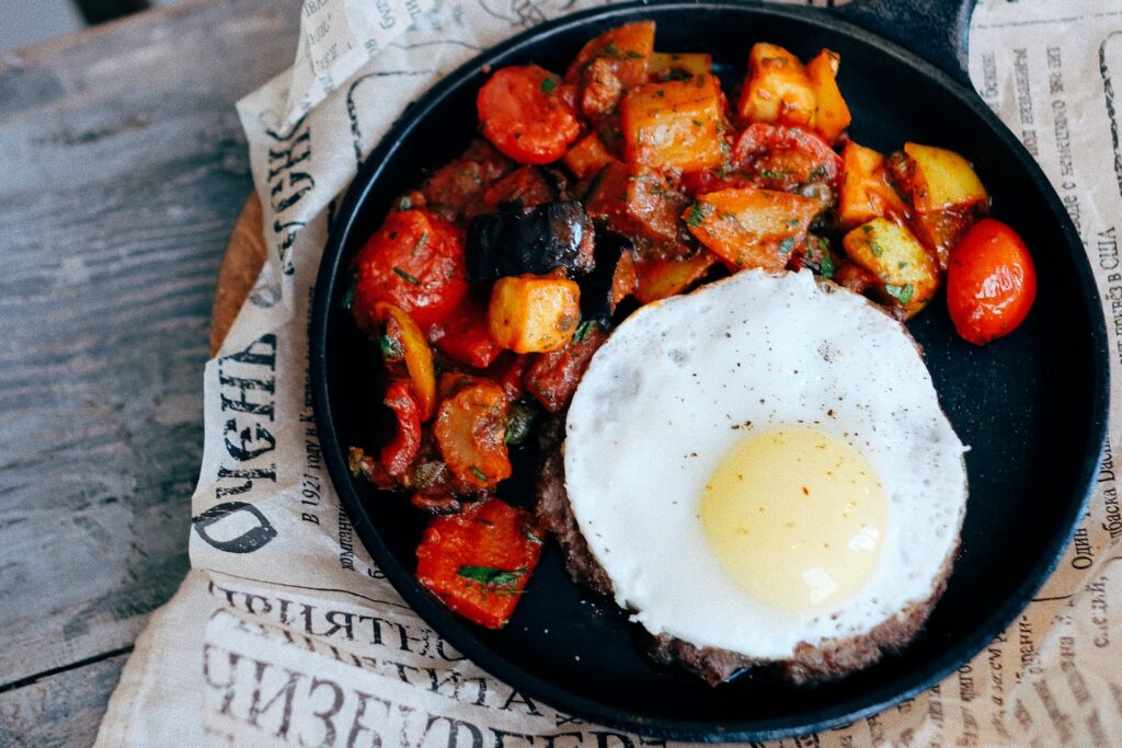 potatoes and egg in cast iron set on newsprint