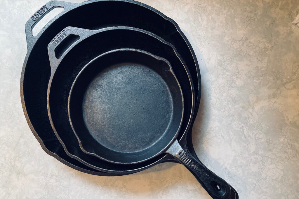 Stacked cast iron cooking pans on countertop