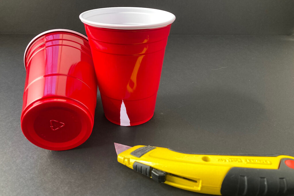 red solo cup and yellow utility knife