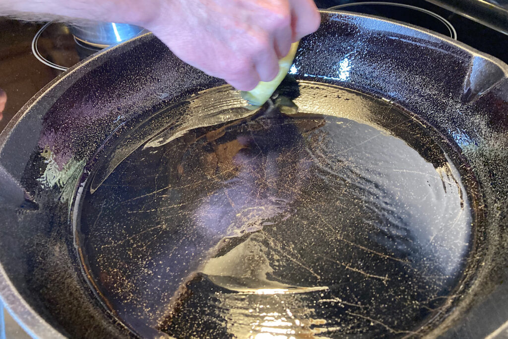 oiling cast iron pan for pizza making