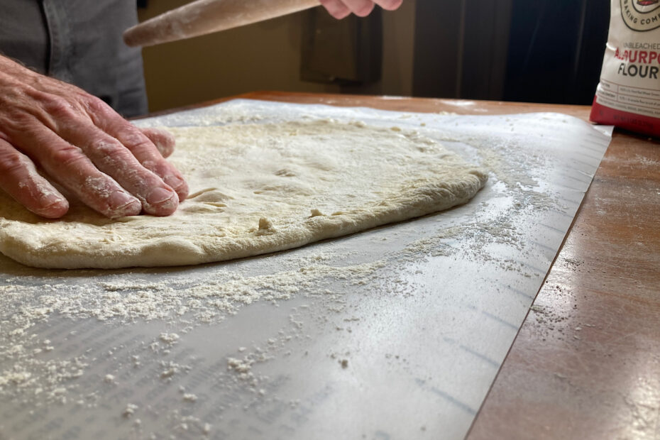 shaping pizza crust on rolling mat