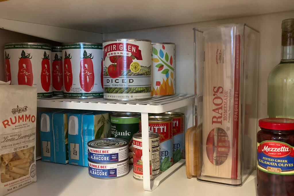 Tomato cans and food items on stackable shelf