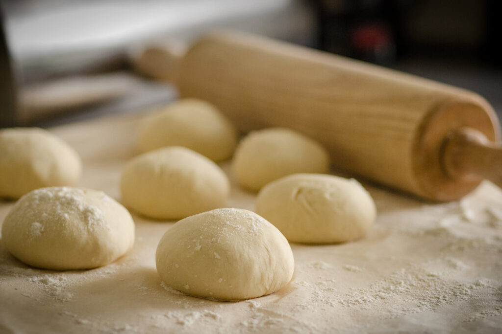 balls of raw dough and rolling pin