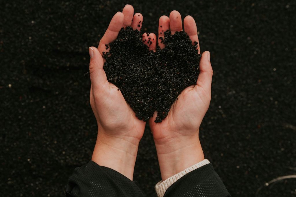 Hands holding dirt shaped in a heart