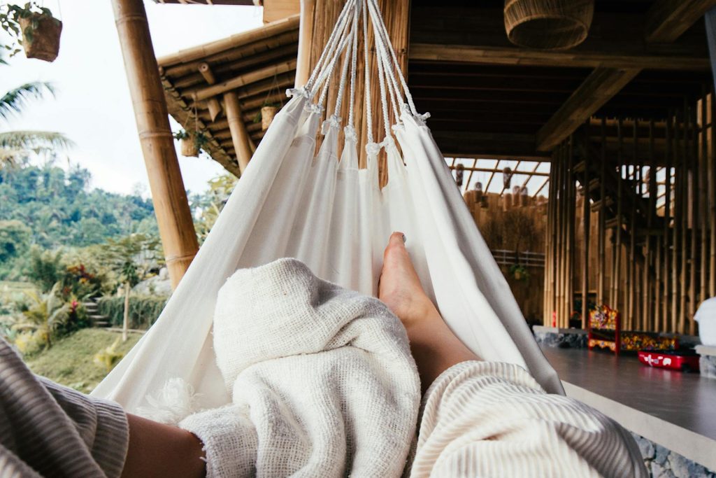 Woman's feet and blanket in white hammock