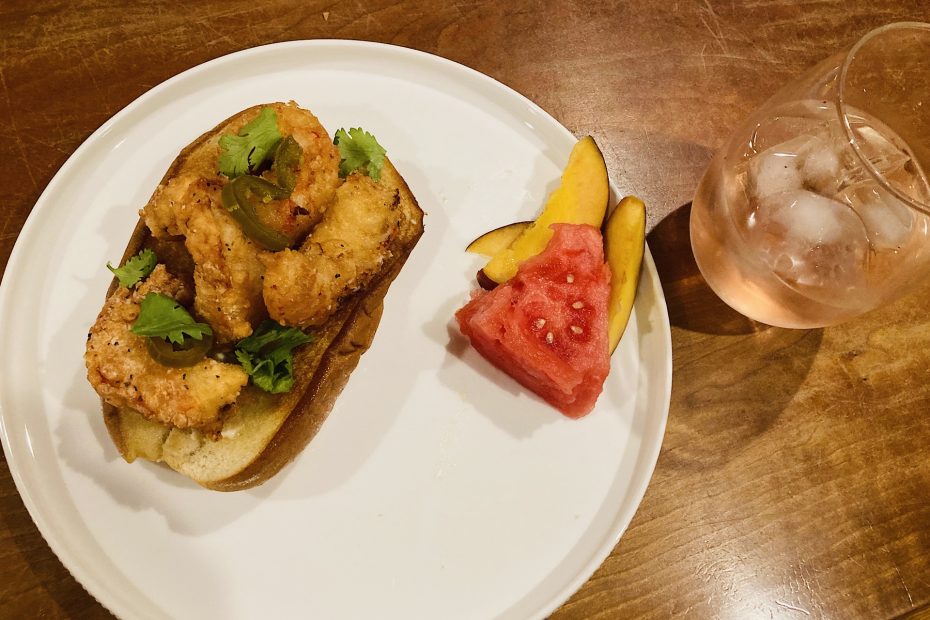 fried shrimp roll with fruit and beverage