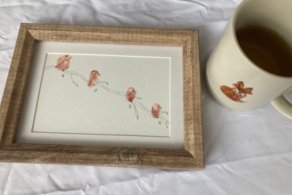 framed fingerprint bird art with cup of coffee beside