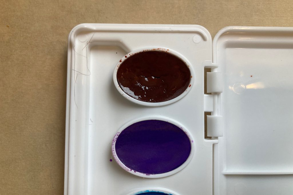 closeup of moistened watercolor paint disk