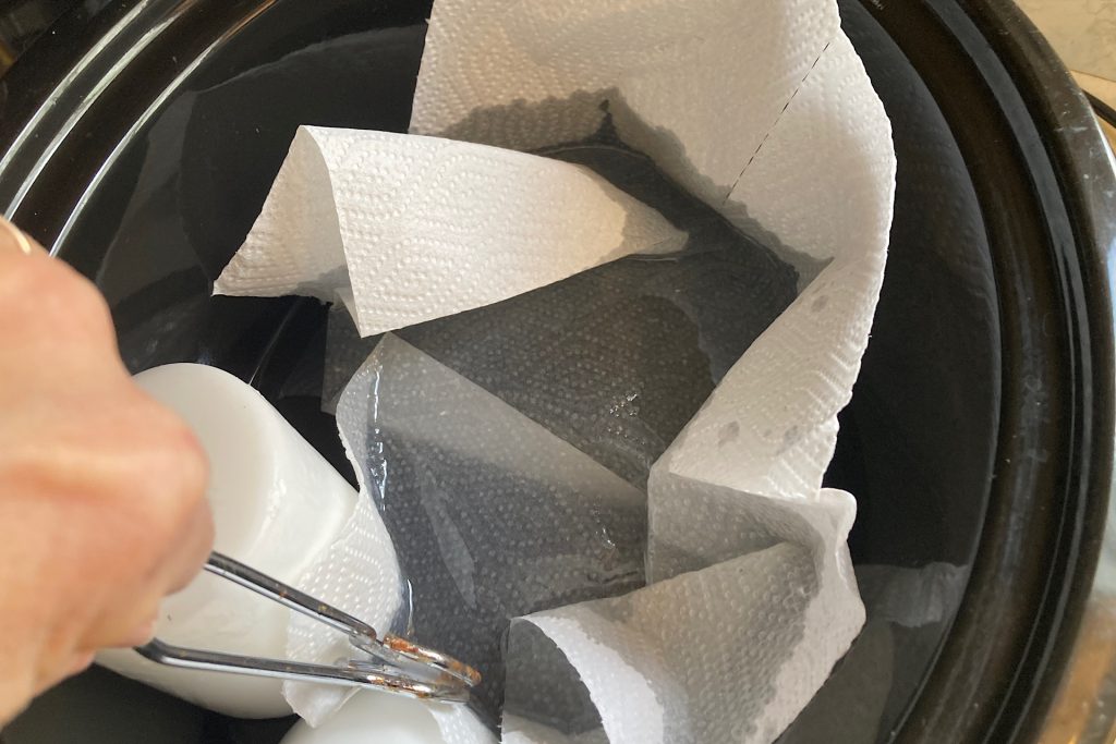 dipping paper towels into melted wax in crockpot