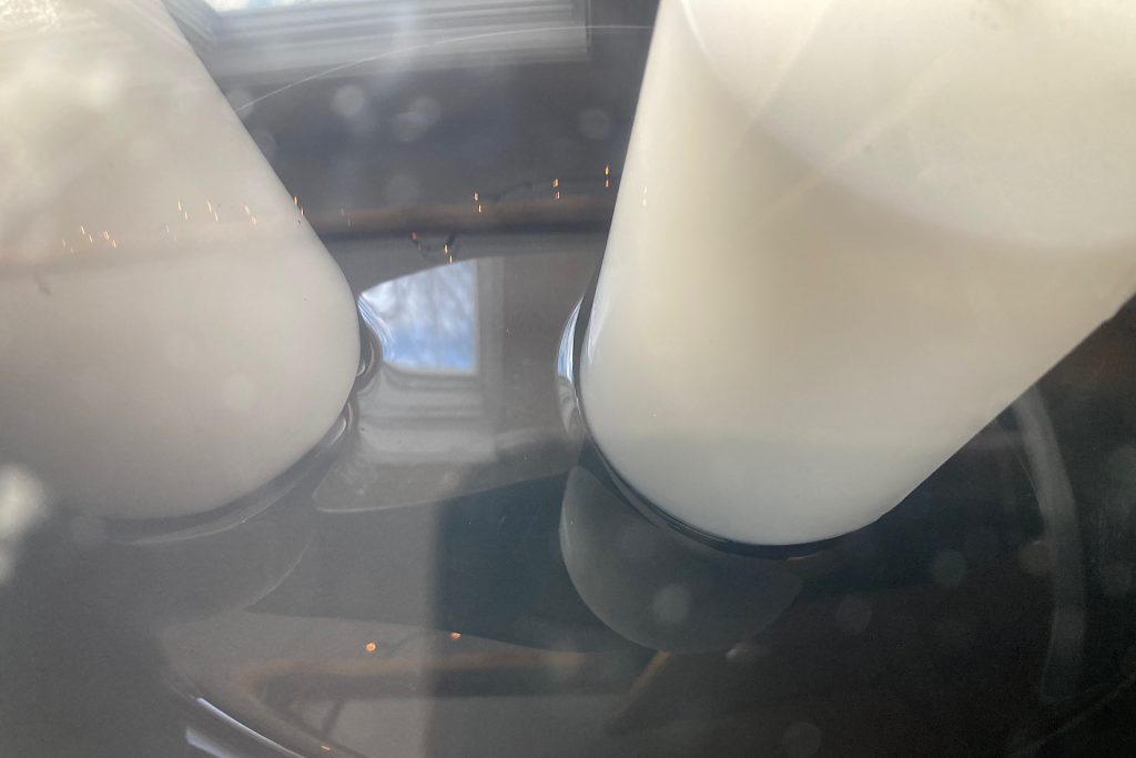 white pillar candles beginning to melt in crockpot