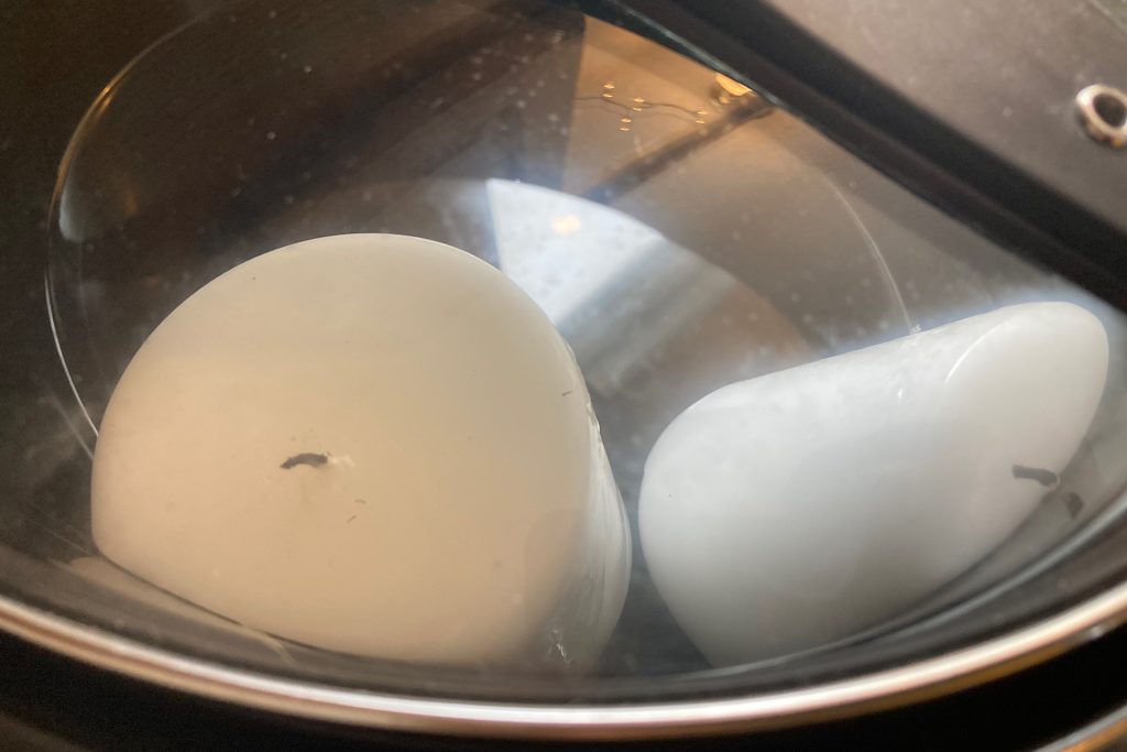 white pillar candles partially melted in crockpot