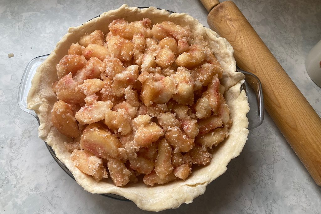 adding filling to bottom crust of grandmother's peach pie recipe