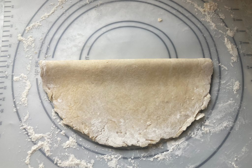 pie crust folded in half on floured mat