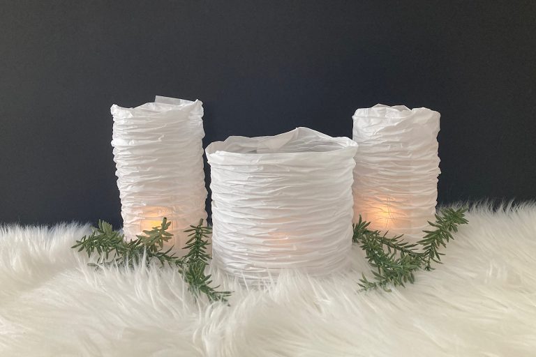 DIY Parchment Paper Lanterns on snowscape with greenery