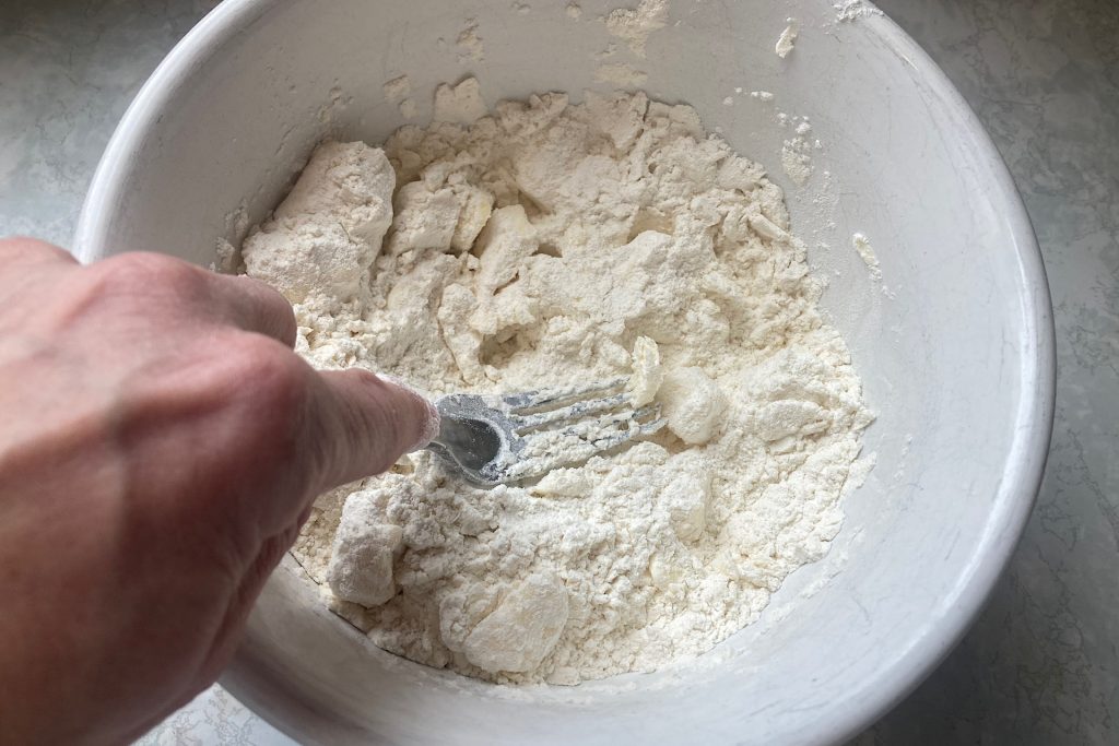 pressing butter slices into flour mixture with fork