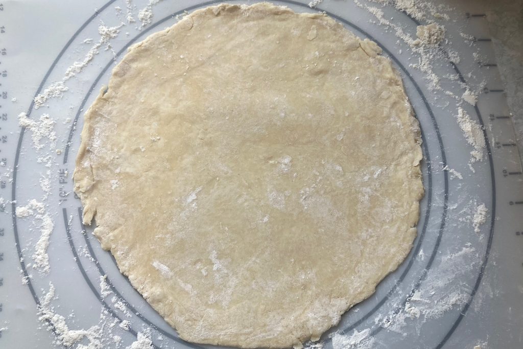 top crust of grandmother's peach pie recipe rolled out on floured mat