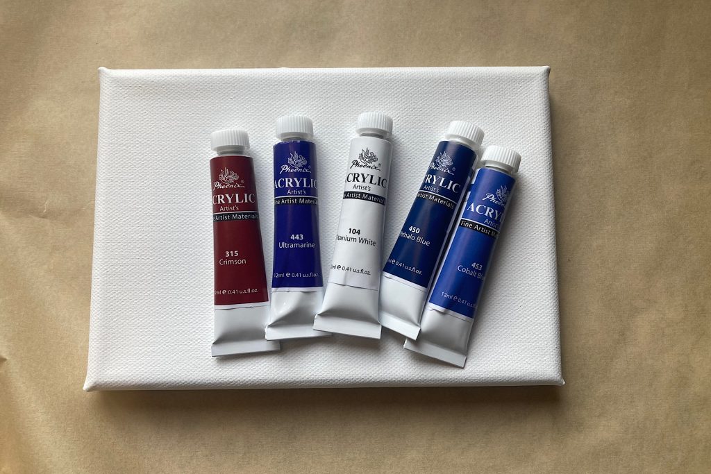 acrylic paint tubes in blues, white and crimson