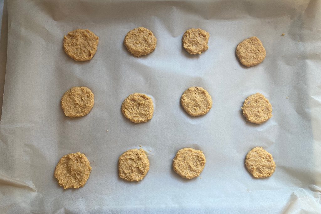 flattened homemade dog biscuits on parchment paper
