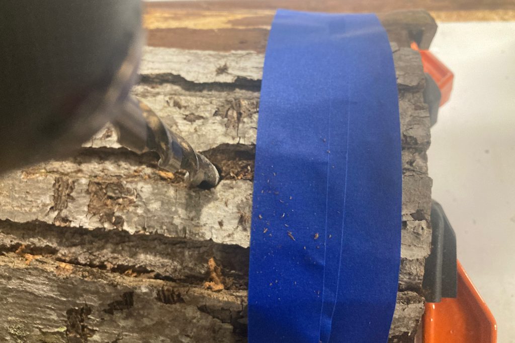 drill bit drilling into log