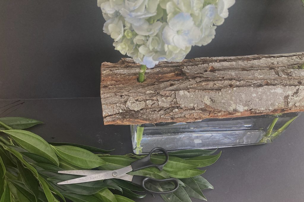 bark, hydrangea bloom, greenery and scissors for woodland floral arrangement