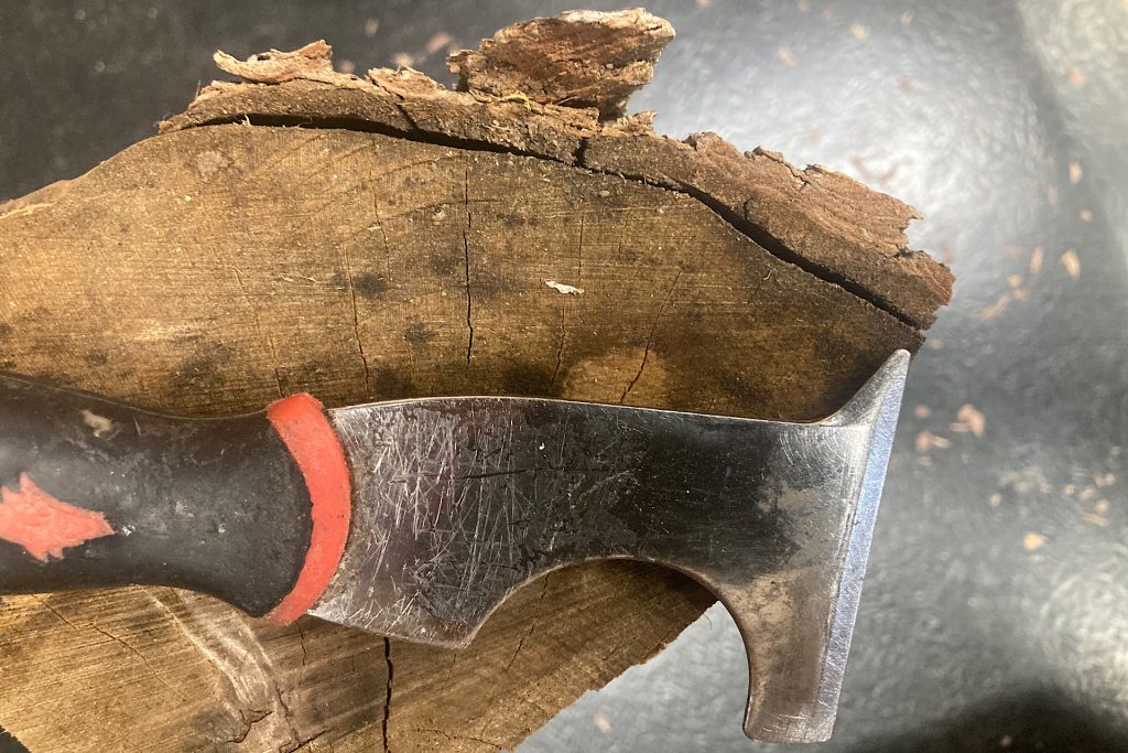 putty knife laying on top of split firewood log